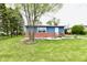 Charming exterior shows brick and blue siding, well-manicured lawn, and decorative white rock landscaping at 1934 N Arlington Ave, Indianapolis, IN 46218