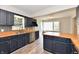 Stylish kitchen boasts navy cabinets, wood countertops, stainless steel appliances, and eye-catching backsplash at 1934 N Arlington Ave, Indianapolis, IN 46218