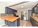 Spacious open kitchen with stainless steel appliances, blue cabinets, butcher block counters, and hardwood floors at 1934 N Arlington Ave, Indianapolis, IN 46218
