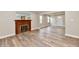 Bright living room featuring new wood flooring and a charming brick fireplace with a wooden mantle at 1934 N Arlington Ave, Indianapolis, IN 46218