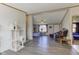 Open-concept living room features light gray floors, a ceiling fan, and seamless access to other living spaces at 220 E Meridian St, Atlanta, IN 46031