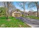 Beautiful home exterior with a two car garage and landscaped front yard with mature trees on a sunny day at 2214 Van Ness Pl, Indianapolis, IN 46240