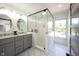 Modern bathroom showcasing double sinks, stylish mirrors, and a glass-enclosed shower with white tile at 2226 N Capitol Ave, Indianapolis, IN 46208