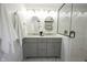 Bathroom featuring double sinks, decorative mirrors, and a glass-enclosed shower with white tiling at 2226 N Capitol Ave, Indianapolis, IN 46208