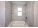 Modern bathroom features gray tile surround, showerhead, bathtub, and glass shelving at 2226 N Capitol Ave, Indianapolis, IN 46208