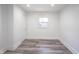 Bedroom with light gray wood flooring, white walls and trim, window, and a door at 2226 N Capitol Ave, Indianapolis, IN 46208