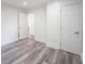 Bedroom with light gray wood flooring, white walls and trim, and two doors at 2226 N Capitol Ave, Indianapolis, IN 46208