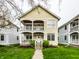 Charming yellow two-story home featuring double porches and a well-manicured lawn at 2316 N Pennsylvania St # 1, Indianapolis, IN 46205