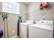 Practical laundry room with a washer, dryer, ironing board, and shelving at 2316 N Pennsylvania St # 1, Indianapolis, IN 46205