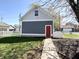 Cozy backyard showing a garage with a red door, framed by a white picket fence at 2419 N Park Ave, Indianapolis, IN 46205