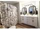 Bathroom with double sink vanity, framed mirrors, and a decorative floral shower curtain at 2419 N Park Ave, Indianapolis, IN 46205