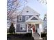 Charming two-story home featuring stylish gray siding, a bright red door, and a welcoming front porch with white railings at 2419 N Park Ave, Indianapolis, IN 46205