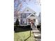 Charming two-story home with gray siding, a red front door, white trim, and a landscaped yard with an American flag at 2419 N Park Ave, Indianapolis, IN 46205