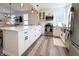 Modern white kitchen with stainless steel appliances, a large island, and stylish pendant lighting, open to living spaces at 2419 N Park Ave, Indianapolis, IN 46205