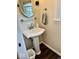 This bathroom features a pedestal sink, a mirrored wall cabinet, and a window letting in natural light at 2605 W Berkshire Dr, Muncie, IN 47304