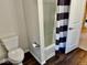 Well-maintained bathroom featuring a toilet, shower with striped curtain, and wood-look flooring at 2605 W Berkshire Dr, Muncie, IN 47304