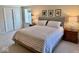 Cozy carpeted bedroom featuring a soft king bed, bedside tables, closet, and two windows at 2605 W Berkshire Dr, Muncie, IN 47304