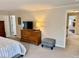 Bright bedroom with carpet floors, soft gray walls, dresser, and open doorway to the hall at 2605 W Berkshire Dr, Muncie, IN 47304
