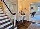 Traditional hallway with wood floors, staircase, and decorated table at 2605 W Berkshire Dr, Muncie, IN 47304