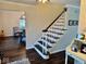 Hallway with hardwood floors, staircase, and views into adjacent dining room at 2605 W Berkshire Dr, Muncie, IN 47304