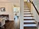 Hallway with view to the kitchen with white cabinetry, and a staircase at 2605 W Berkshire Dr, Muncie, IN 47304