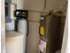 A utility room featuring a water softener system and a hot water heater for home use at 2715 S 300 E, Anderson, IN 46017