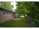 Exterior shot reveals a cozy patio area and well-maintained yard surrounded by mature trees at 3140 Bonham Dr, Indianapolis, IN 46222