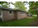 View of exterior, highlighting stone detail, windows, well-kept lawn and a small patio area at 3140 Bonham Dr, Indianapolis, IN 46222