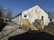 A cozy home with a wood deck, a gravel driveway, and a lush green lawn at 3233 N Tacoma Ave, Indianapolis, IN 46218