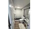 A newly renovated bathroom featuring a tiled shower, modern fixtures, and a pedestal sink at 3233 N Tacoma Ave, Indianapolis, IN 46218
