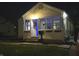 Charming home exterior featuring a wreath on the front door and cozy window planters at nighttime at 3233 N Tacoma Ave, Indianapolis, IN 46218