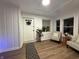Bright living room featuring white wainscoting, light wood floors, and a decorative front door at 3233 N Tacoma Ave, Indianapolis, IN 46218