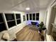 Inviting sunroom with a fireplace, wood floors, and ample natural light at 3233 N Tacoma Ave, Indianapolis, IN 46218