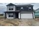 Two-story home featuring a two-car garage with black and white accents and unfinished landscaping at 3315 Godby Dr, Sheridan, IN 46069