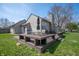 Spacious backyard showcasing a raised wood deck, table set, and stone chimney at 3510 Oak Tree Cir, Indianapolis, IN 46227