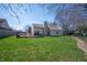 Large grassy backyard with wood deck, stone chimney, and partial fence line at 3510 Oak Tree Cir, Indianapolis, IN 46227