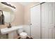 Half bathroom featuring a pedestal sink, toilet, wainscotting and sliding door closet at 3510 Oak Tree Cir, Indianapolis, IN 46227