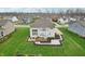 Spacious backyard featuring a wooden deck, stone path, and manicured garden beds at 3665 Conifer Dr, Zionsville, IN 46077
