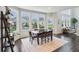Cozy dining area with dark wood table set near large windows offering backyard views in a well-lit space at 3665 Conifer Dr, Zionsville, IN 46077
