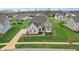 Beautiful aerial view of home with stone accents, a well-manicured lawn, and new landscaping at 3665 Conifer Dr, Zionsville, IN 46077