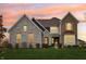 Stunning two-story house with stone and brick exterior, enhanced by a vibrant sunset backdrop at 3665 Conifer Dr, Zionsville, IN 46077