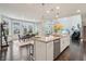 Open-concept kitchen with a large island, granite countertops, and pendant lighting adjoining dining area and living space at 3665 Conifer Dr, Zionsville, IN 46077