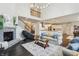 Open-concept living room with fireplace, staircase, and a view of the modern kitchen area at 3665 Conifer Dr, Zionsville, IN 46077