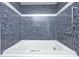 Luxurious bathroom featuring a soaking tub surrounded by beautiful blue mosaic tile at 3753 Whippoorwill Lake S Dr, Monrovia, IN 46157