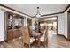 Dining room with wood floors, trim, a glass display cabinet, and a view into the kitchen at 3753 Whippoorwill Lake S Dr, Monrovia, IN 46157