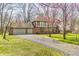Traditional home with an attached garage and a spacious driveway, surrounded by greenery and mature trees at 3753 Whippoorwill Lake S Dr, Monrovia, IN 46157