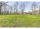 A verdant front lawn ascends to a charming house nestled among the bare trees at 3753 Whippoorwill Lake S Dr, Monrovia, IN 46157