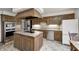 Kitchen boasts custom wood cabinets, stainless steel appliances, an island cooktop, and tile backsplash at 3753 Whippoorwill Lake S Dr, Monrovia, IN 46157
