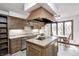 Charming kitchen features custom island cooktop, stained cabinets, and an adjacent breakfast nook with leaded glass windows at 3753 Whippoorwill Lake S Dr, Monrovia, IN 46157