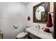 Powder room with pedestal sink, mirror with stained glass accents, and decorative towel hook at 3753 Whippoorwill Lake S Dr, Monrovia, IN 46157